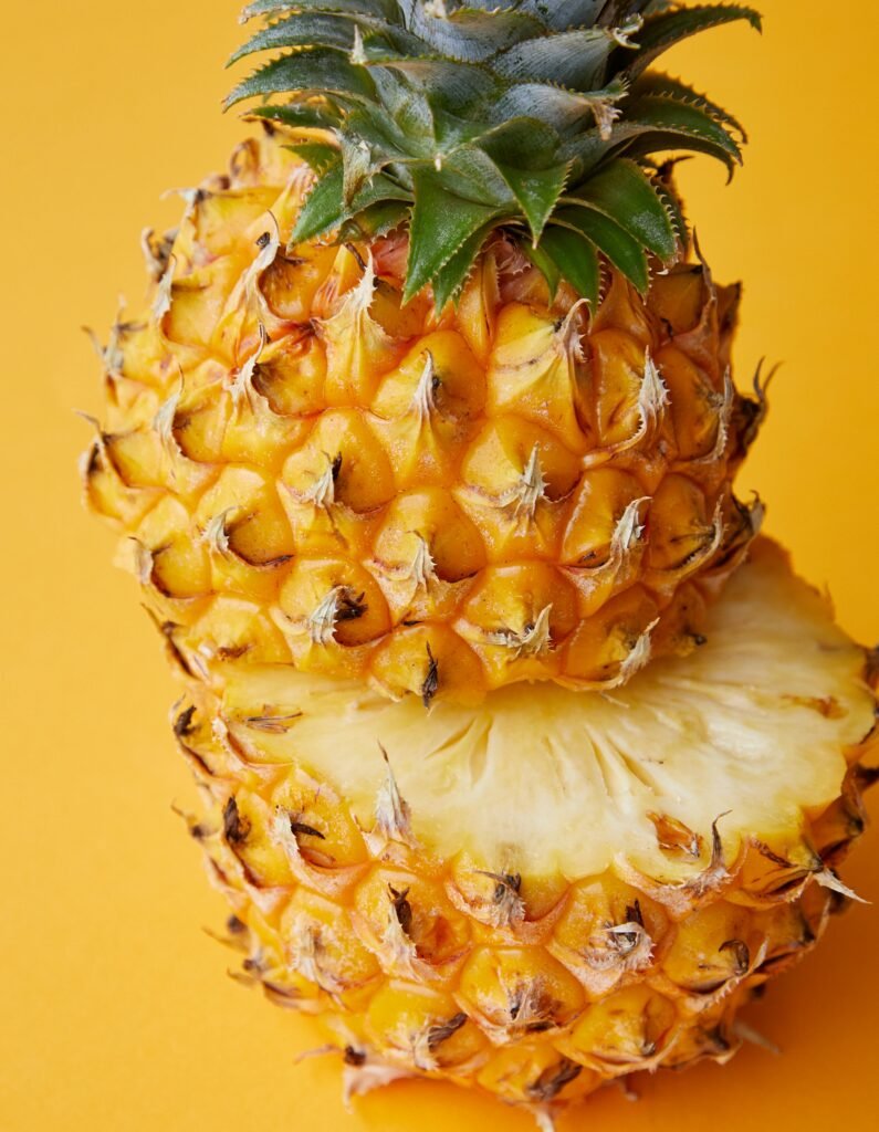 Juicy pineapple cut open on vibrant yellow background, highlighting its freshness and tropical vibe.